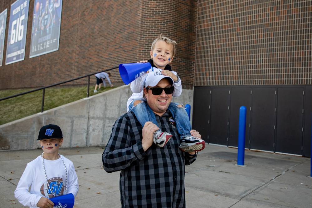 An alum and his child walking to the game.